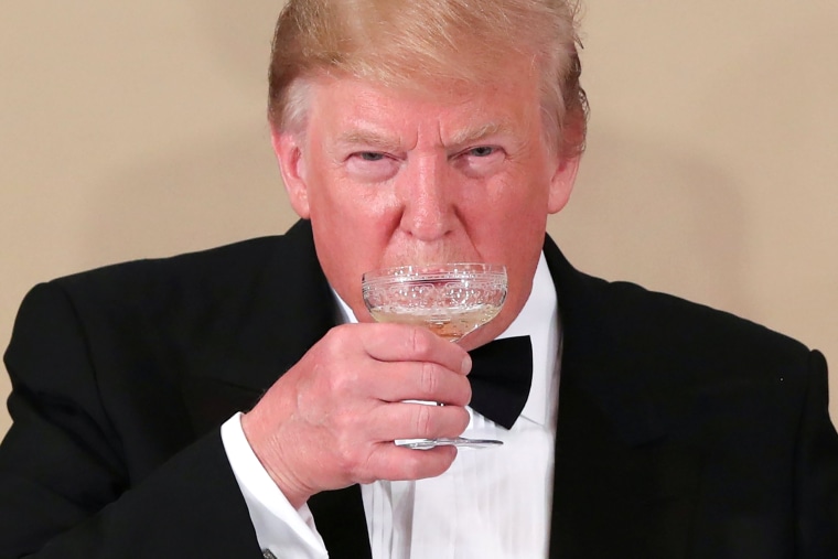 Image: President Donald Trump drinks during a state banquet at the Imperial Palace in Tokyo