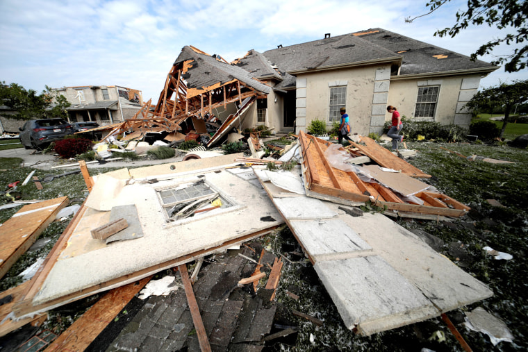 Image: Neighbors gather belongings after houses were damaged after a tornado touched down overnight near Dayton, Ohio