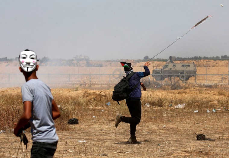 Image: Palestinian demonstrators hurl rocks at Israeli soldiers in the Gaza Strip on May 15.