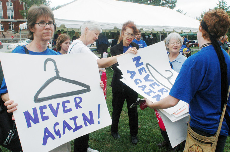 Melanie Curtis, left, waits as MIldred Rutan, second left, looks through a selection of protest signs offered by Planned Parenthood volunteer Cara Bates, right back to camera, at an abortion rights rally Wednesday morning, Sept. 14, 2005, at the State Capitol in Jefferson City, Missouri. The women, all of Springfield, joined about 150 other people demonstrating against further restrictions on abortions which are expected to be approved by Missouri legislators during the special session.