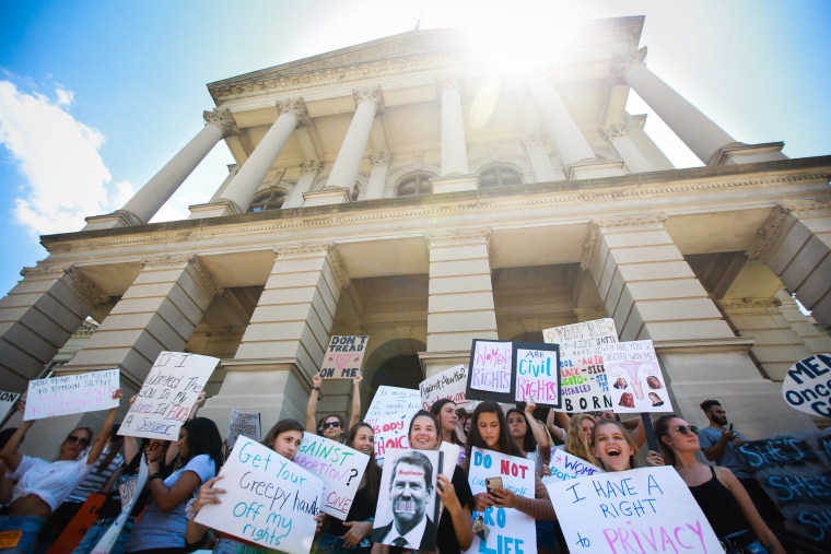 Demonstrators hold signs protesting recently passed abortion ban bills at the Georgia State Capitol building on May 21, 2019 in Atlanta.