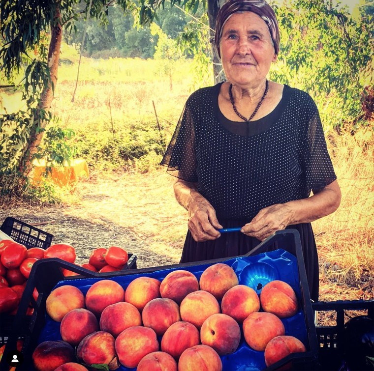 An eldery Sardinian female farmer selling produce on a side road in Sardinia.