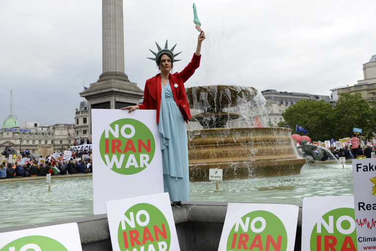 Image: A protester holds a placard that says no iran war during the Anti-Trump protest in London