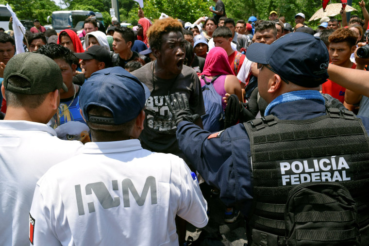 Image: A migrant argues with a federal police officer during a joint operation by the Mexican government to stop a caravan of Central American migrants on their way to the U.S., at Metapa de Dominguez