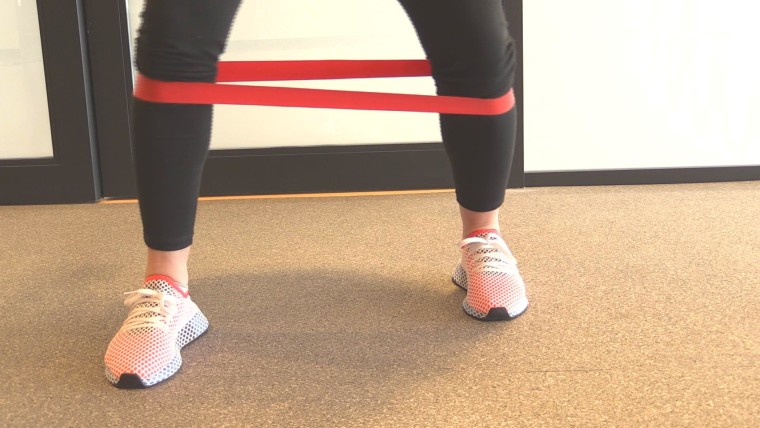 Monique Lamoureux-Morando demonstrating lower body exercises with a resistance band.