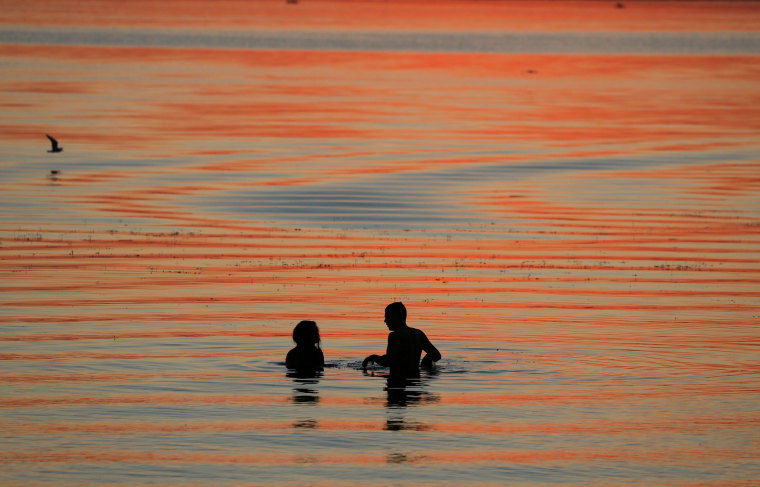 Image: People enjoy sunset in a lake on the outskirts of Minsk