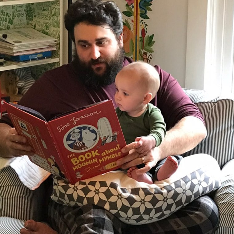 Zavo Gabriel reads a book to his baby boy, Arthur. 
