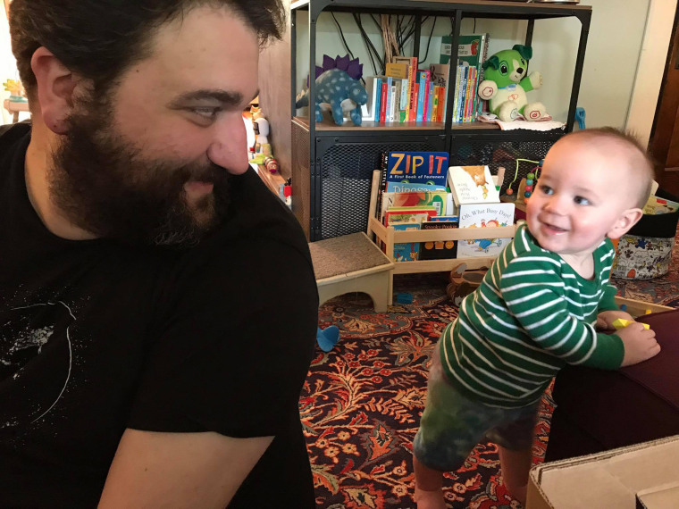 Zavo Gabriel and his infant son, Arthur, smile at each other.