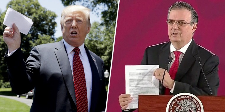President Donald Trump waves a sheet of paper he claims contains a secret agreement with Mexico on Tuesday. On Monday, Mexican Foreign Secretary Marcelo Ebrard pointed to his own sheet of paper, saying no such secret agreement exists.