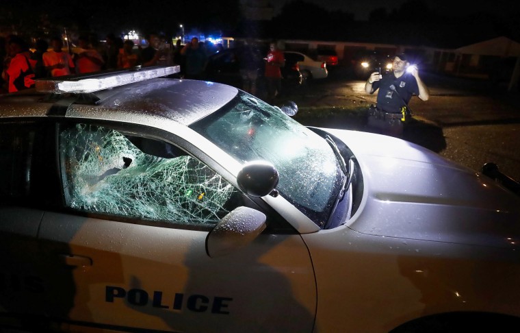 Image: A Memphis police officer looks over a damaged squad car after protesters took to the streets of the Frayser community in anger against the shooting a youth by U.S. Marshals earlier in the evening