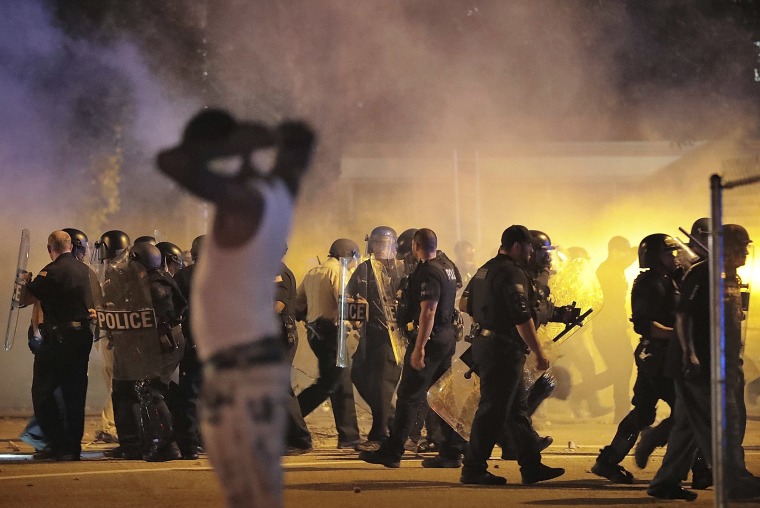Image: Police retreat under a cloud of tear gas as protesters disperse from the scene of a standoff after Frayser community residents took to the streets in anger against the shooting of a youth by U.S. Marshals