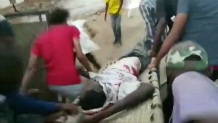 Image: An injured man is carried on a stretcher during protests in Khartoum