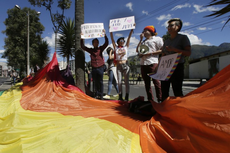 Gay rights activists holds signs that read "Equal marriage" and "Love and let love" outside of the Constitutional Court
