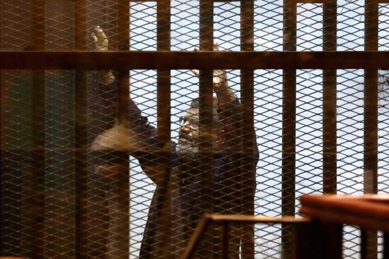 Image: Egypt's ousted Islamist President Mohammed Morsi gestures in a defendants cage