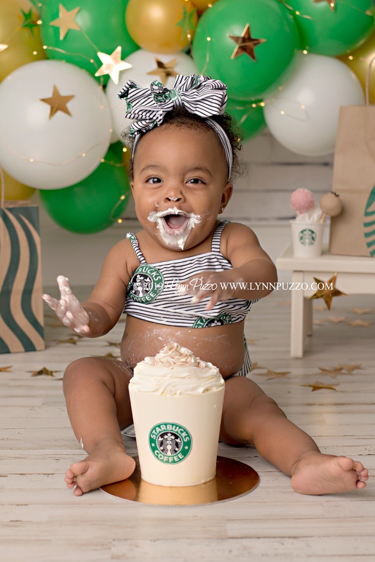 Baby Aria digs into a Starbucks smash cake, thrilled to taste buttercream for the first time.