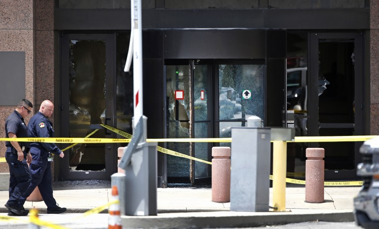 Image: Dallas police walk past the bullet-riddled glass doors of the Earle Cabell Federal Building on June 17, 2019.