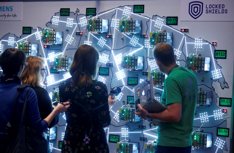 Image: People look at visualizations at a cyber defense exercise organize by NATO Cooperative Cyber Defence Centre of Excellence in Estonia on April 10, 2019.