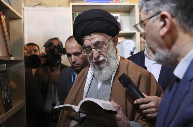 Image: Supreme Leader Ayatollah Ali Khamenei reads part of a book while visiting Tehran's book fair in Tehran, Iran