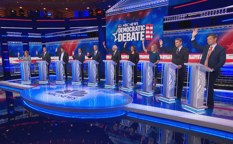 Democratic candidates raise their hands to answer whether they would cover undocumented immigrants in the second Democratic primary debate of the 2020 presidential campaign season hosted by NBC News at the Adrienne Arsht Center for the Performing Arts in Miami, Florida on June 27, 2019.