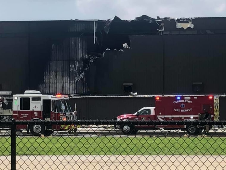 First responders attend to the scene of the crash, a charred hangar at Addison Airport.