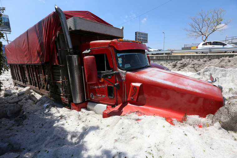Image: A truck is buried in ice after a heavy storm of rain and hail which  affected some areas of the city in 