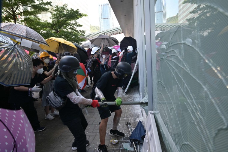 Image: Protesters attempt to break a window at the government headquarters in Hong Kong