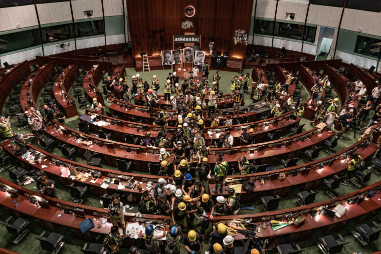 Image: Protesters leave the legislative chamber