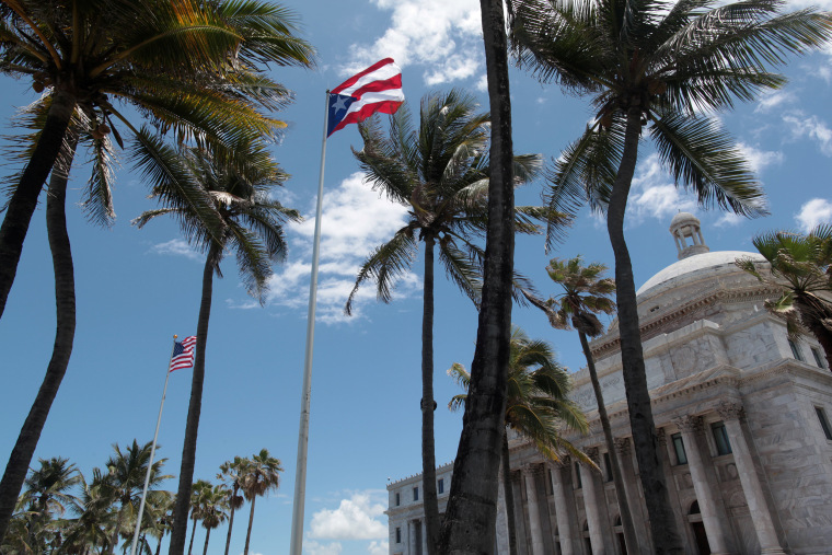 Image: The flags of the U.S. and Puerto Rico fly outside the Capitol building in San Juan