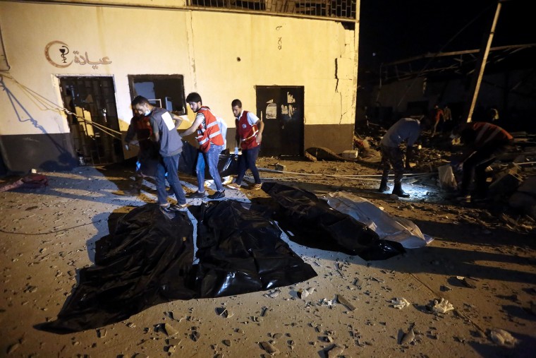 Image: Emergency workers recover bodies after an airstrike killed dozens at Tajoura Detention Center near Tripoli 