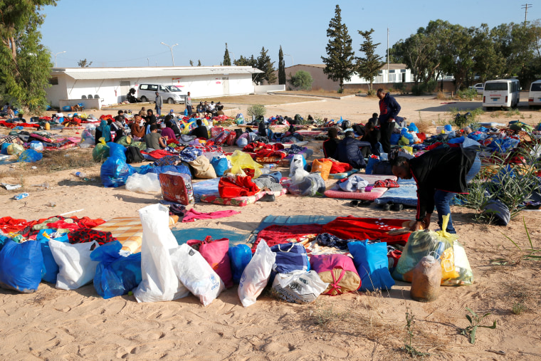 Image: Migrants are seen with their belongings at a detention centre for mainly African migrants, hit by an airstrike, in the Tajoura suburb of Tripoli