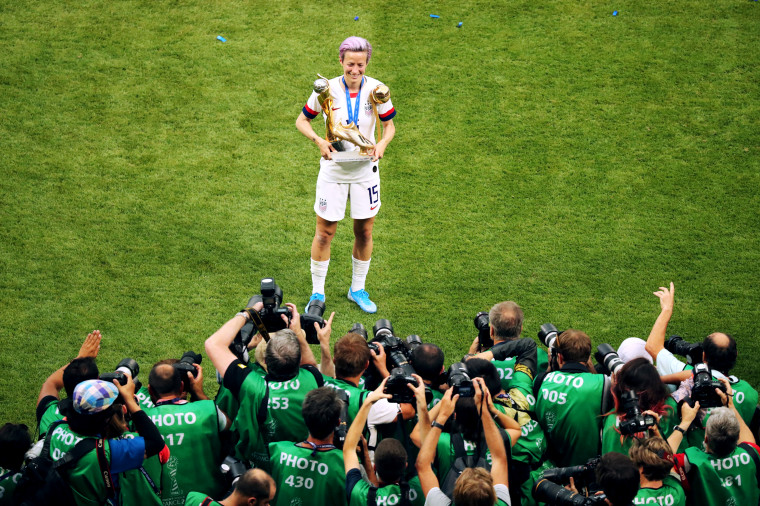 Image: Megan Rapinoe poses with the World Cup trophy and her Golden Boot and Golden Ball trophies after winning the Women's World Cup against the Netherlands on July 7, 2019.