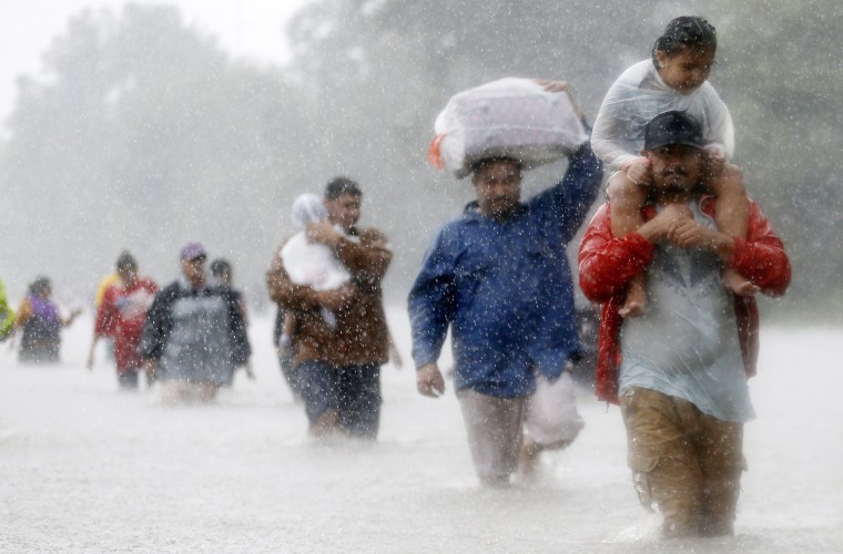 Image: Residents wade through flood waters from Tropical Storm Harvey in Beaumont Place, Houston