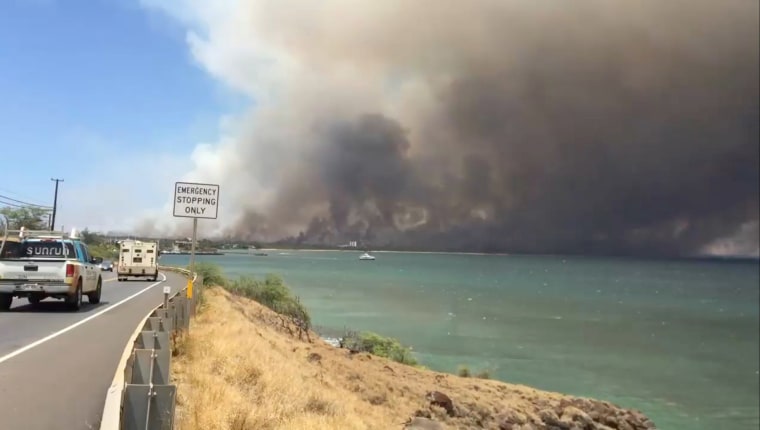 Image: A plume of smoke spreads across the sky during a wildfire in Kihei