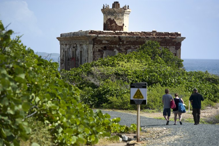 Tourists walk toward Ferro Port lighthouse, at Verdiales Key point on the south coast of Vieques island, Puerto Rico on Jan. 13, 2017. The tiny island long known for a former Navy bombing range is gradually working toward a different sort of boom: a growing tourist mecca.
