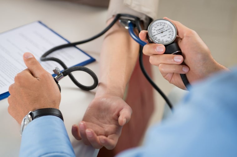 Image: A doctor checks a patient's blood pressure