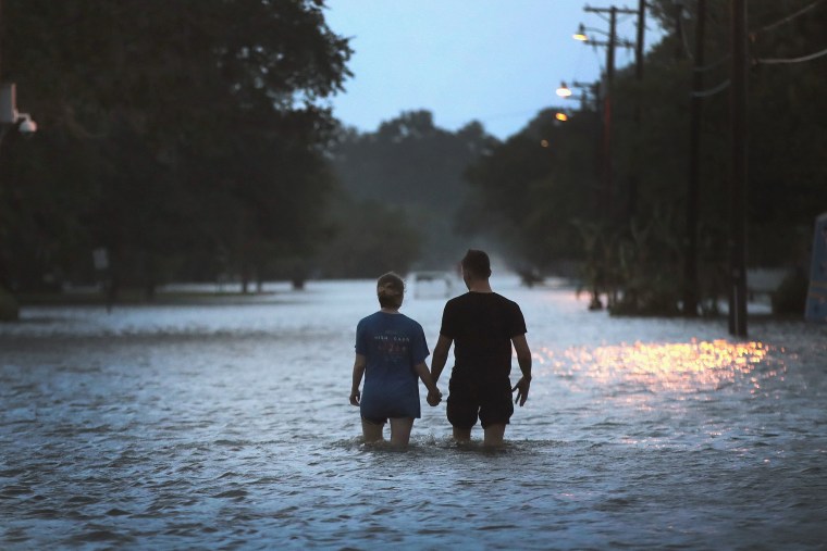 Image: A couple stroll down Lakeshore Drive along the shore of Lake Pontchartrain after it was flooded in the wake of Hurricane Barry on July 13, 2019 in Mandeville, Louisiana.