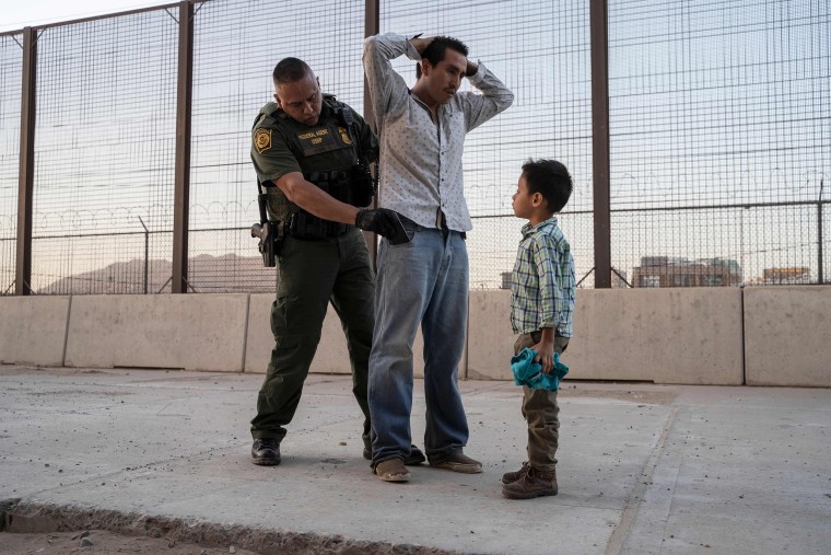 Image: Jose, 27, with his son Jose Daniel, 6, is searched by U.S. Customs and Border Protection Agent Frank Pino, in El Paso, Texas.