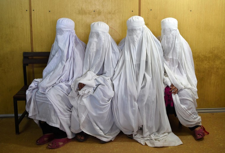 Image: Afghan refugee women wait to scans their eyes at the UNHCR registration centre in the Pakistani city of Peshawar