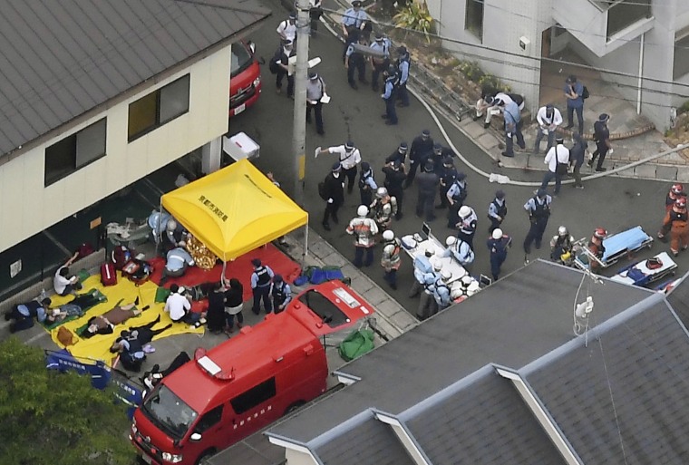 Image: Rescue workers carry injured people from the three-story Kyoto Animation building which was torched in Kyoto