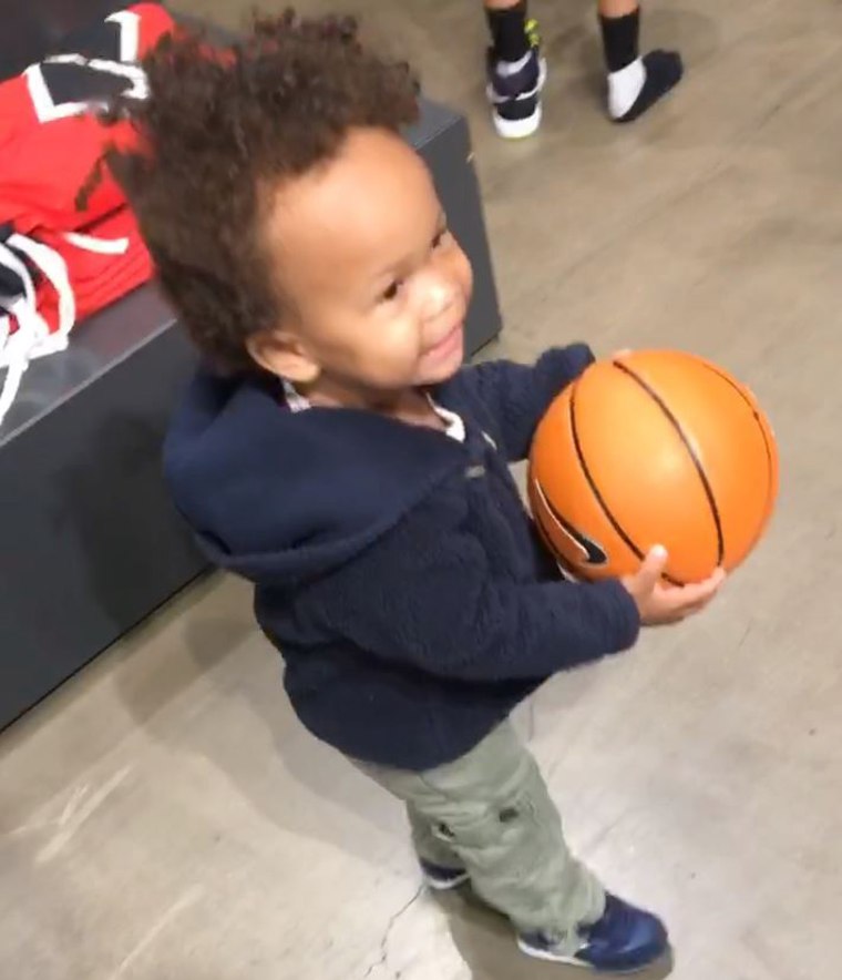 Joel Stallworth and TaMiya Dickerson's son Sammy holds a basketball they purchased at Santa Monica Place.