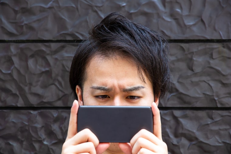 A man looks at his mobile phone