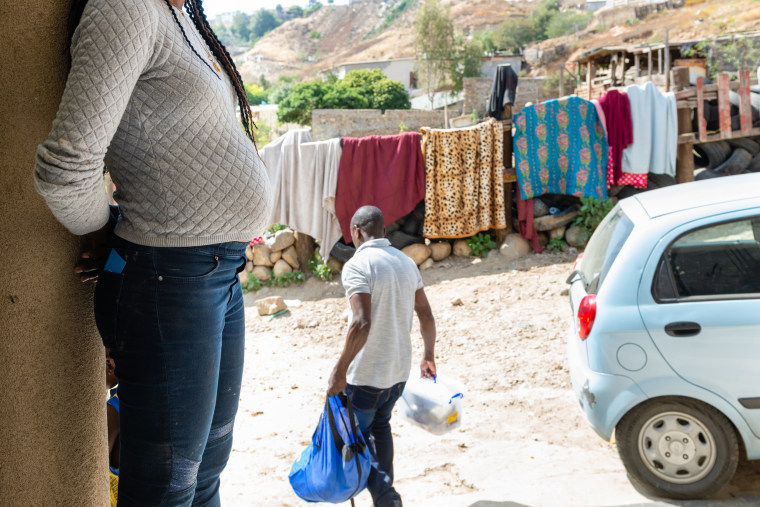 Daniela Pierre, who has been living in a Tijuana shelter for three months while the U.S. government considers her asylum application, waits as her husband takes their laundry to be washed. Pierre fled Haiti four years ago after the economy collapsed and ended up in Venezuela. But the political turmoil there forced her to keep moving, she says, and she spent four months traveling by bus and foot to the U.S. border. 