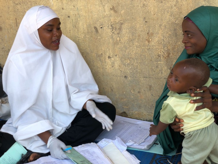 Aisha Shuaibu Mohammad, a vaccinator trained by UNICEF volunteer community leaders, discusses vaccine safety with, Amina Anas.