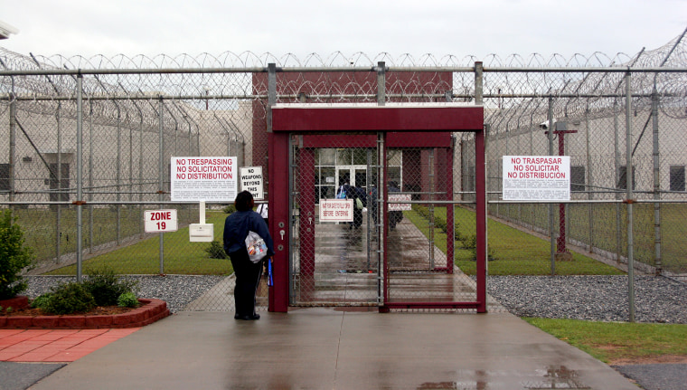 An employee waits at the front gate of the Stewart Detention Facility, a Corrections Corporation of America immigration facility in Lumpkin, Georgia, on April 13, 2009.