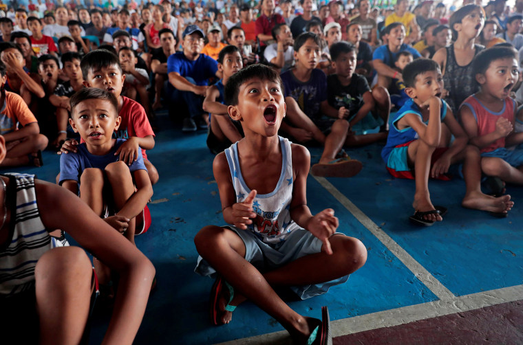Image: Filipino boxing fans celebrate after Manny Pacquiao wins the WBA Welterweight fight against Keith Thurman of the U.S. during a live public viewing of the match in Marikina