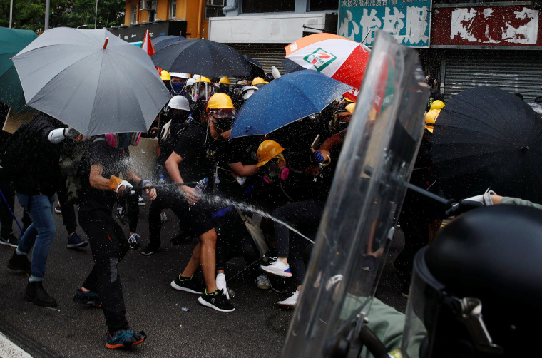 Image: Police officers use pepper spray on protesters on Saturday. 