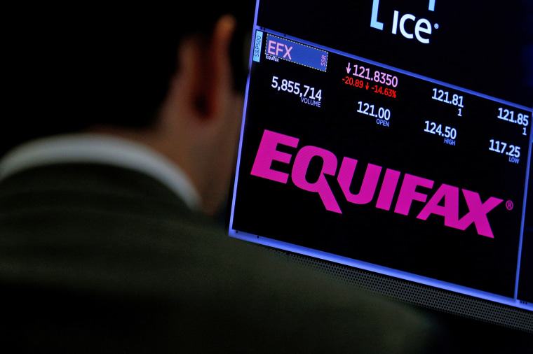 Trading information and the company logo are displayed on a screen where the stock is traded on the floor of the NYSE in New York