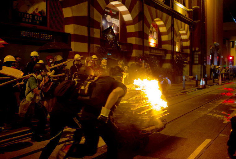 Image: Protesters push a burning cart towards police during a demonstration in the Sheung Wan district of Hong Kong on July 28, 2019.
