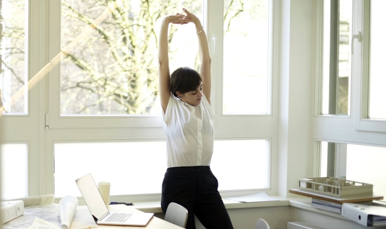 Image: Woman doing stretching exercise in her office