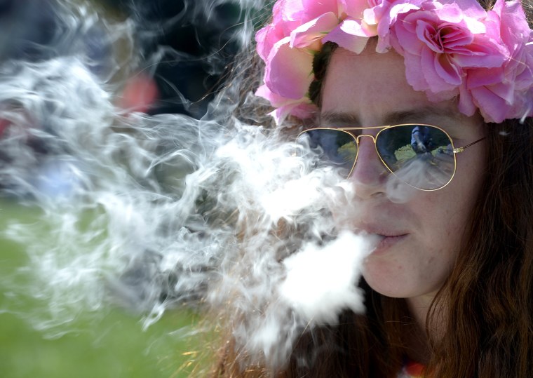 Image: A woman smokes marijuana during the 4/20 Rally at the Civic Center in Denver